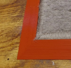 Wheel-friendly, sloped carpet edge frame (anti corner lift)